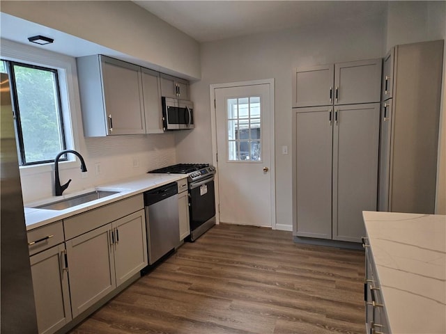 41 Garnet St, Rochester, NY 14609 - kitchen with appliances with stainless steel finishes, gray cabinets, dark wood-style flooring, and backsplash