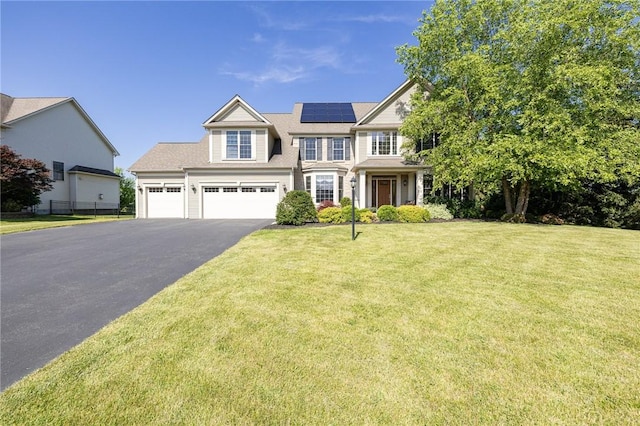 4 Crowne Pointe Dr, Penfield, NY 14526 - view of front of home featuring driveway, roof mounted solar panels, and a garage