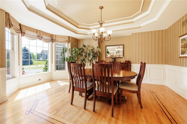 4 Crowne Pointe Dr, Penfield, NY 14526 - dining room with a tray ceiling, light wood finished floors, a chandelier, ornamental molding, and a decorative wall