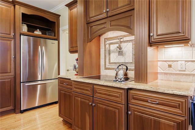 4 Crowne Pointe Dr, Penfield, NY 14526 - kitchen featuring stainless steel refrigerator, tasteful backsplash, light stone countertops, black electric stovetop, and ornamental molding