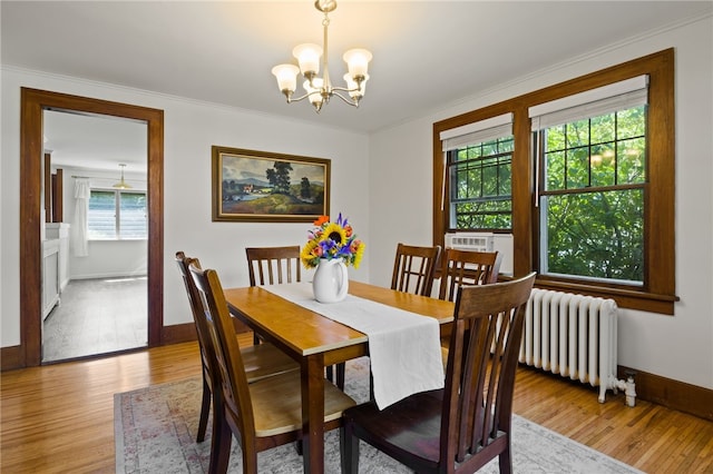 29 Stonehenge Rd, Irondequoit, NY 14609 - dining space featuring radiator, a chandelier, light wood-style flooring, crown molding, and cooling unit