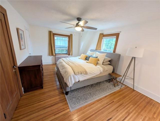 29 Stonehenge Rd, Irondequoit, NY 14609 - bedroom featuring radiator heating unit, light wood-style flooring, and a ceiling fan