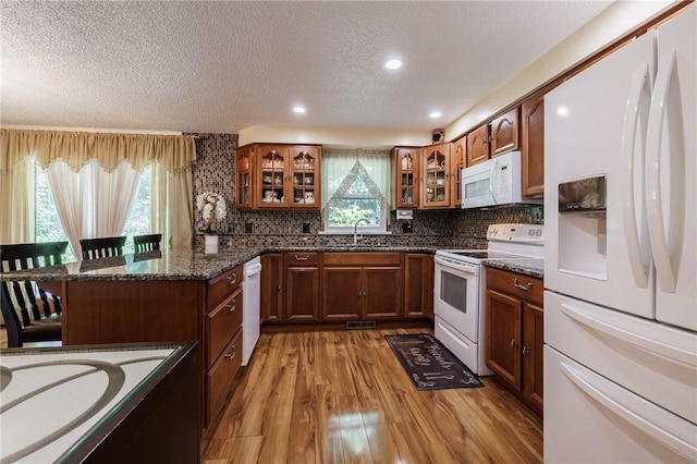 18 Chesterton Ct, Perinton, NY 14450 - kitchen featuring white appliances, a textured ceiling, healthy amount of natural light, light wood-type flooring, and a peninsula