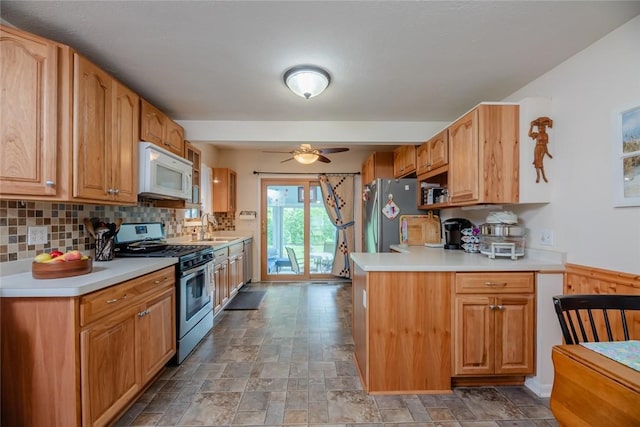 229 Angelus Dr, Irondequoit, NY 14622 - kitchen featuring stainless steel appliances, light countertops, light stone finish floors, backsplash, and ceiling fan