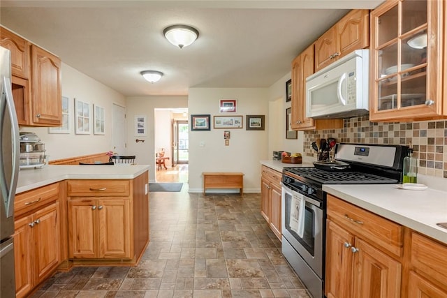 229 Angelus Dr, Irondequoit, NY 14622 - kitchen with appliances with stainless steel finishes, light countertops, a peninsula, tasteful backsplash, and dark stone finish floors