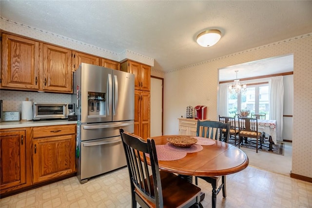 112 Pin Oak Ln, Irondequoit, NY 14622 - kitchen featuring stainless steel fridge with ice dispenser, light floors, brown cabinetry, a chandelier, and wallpapered walls