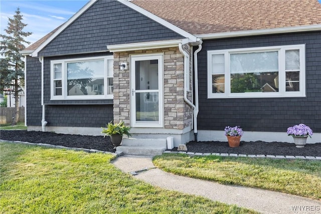 47 Waverly Ave, Tonawanda, NY 14217 - view of front of home with stone siding, a front yard, and roof with shingles