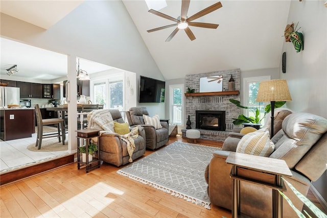 346 Willowood Dr, Greece, NY 14612 - living area featuring a ceiling fan, healthy amount of natural light, light wood finished floors, high vaulted ceiling, and a brick fireplace