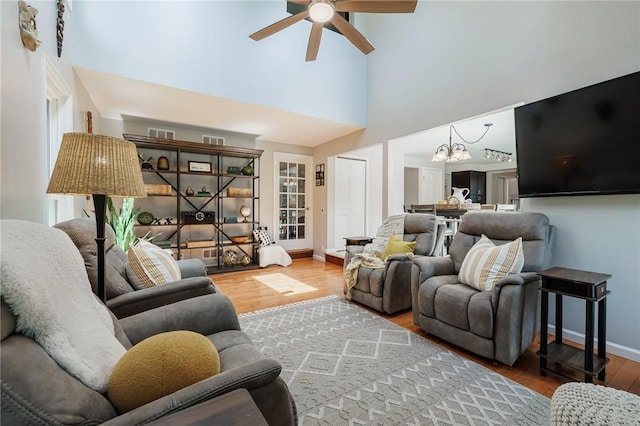 346 Willowood Dr, Greece, NY 14612 - living area featuring wood finished floors, a ceiling fan, a towering ceiling, plenty of natural light, and a chandelier