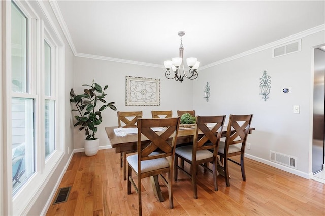 346 Willowood Dr, Greece, NY 14612 - dining space with a chandelier, crown molding, and light wood finished floors