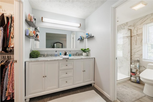 346 Willowood Dr, Greece, NY 14612 - full bathroom featuring a shower stall, double vanity, a spacious closet, and wood finished floors