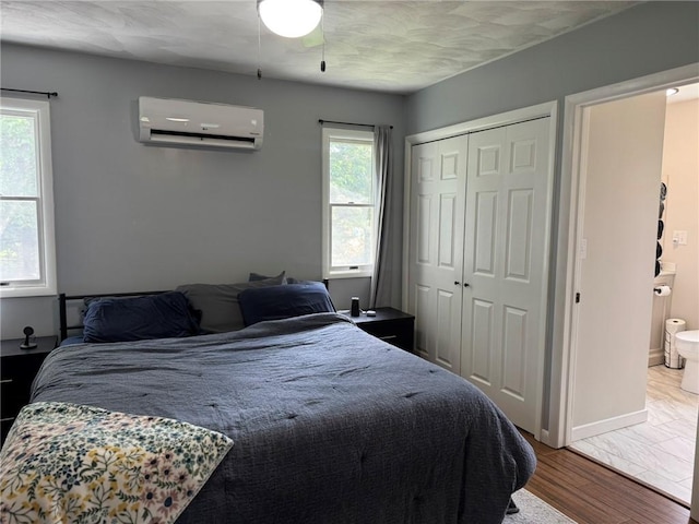 504 Whites Hill Rd, Guilford, NY 13780 - bedroom featuring a wall mounted air conditioner, multiple windows, a closet, and wood finished floors