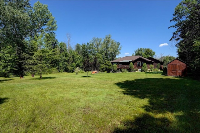 1622 Magog Rd, Macedon, NY 14502 - view of green lawn with a storage unit and a wooden deck