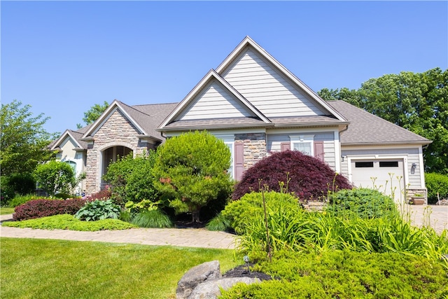 84 Watersong, Penfield, NY 14580 - view of front of property with stone siding, an attached garage, driveway, and a front lawn