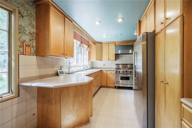 500 Pine Grove Ave, Irondequoit, NY 14617 - kitchen with appliances with stainless steel finishes, light countertops, a peninsula, backsplash, and pendant lighting