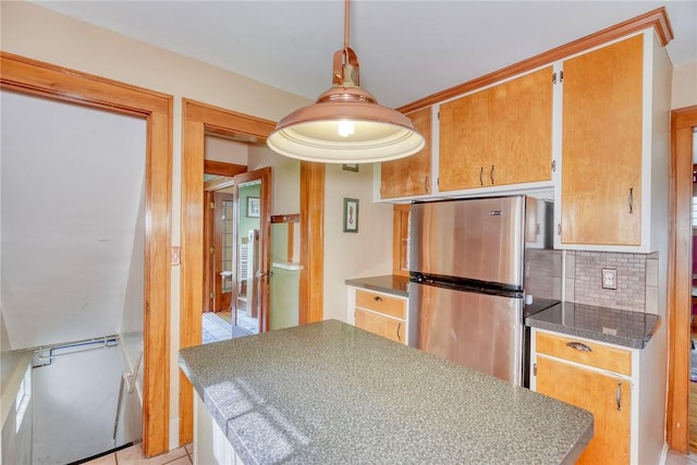 103 Culver Pkwy, Irondequoit, NY 14609 - kitchen featuring freestanding refrigerator, tasteful backsplash, a center island, dark countertops, and light tile patterned flooring