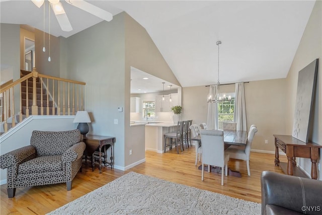 5269 Medasano Cir, Clay, NY 13041 - dining area featuring light wood finished floors, a ceiling fan, stairway, a chandelier, and high vaulted ceiling