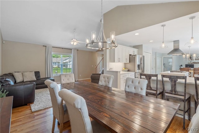 5269 Medasano Cir, Clay, NY 13041 - dining space featuring lofted ceiling, a chandelier, light wood-style flooring, ceiling fan, and stairway