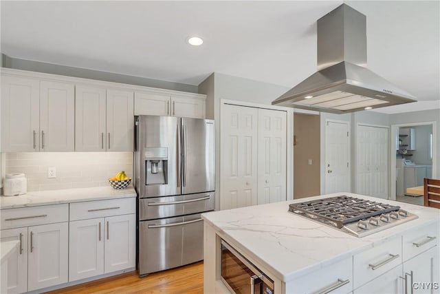 5269 Medasano Cir, Clay, NY 13041 - kitchen with appliances with stainless steel finishes, wall chimney exhaust hood, independent washer and dryer, white cabinetry, and recessed lighting