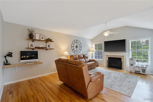 5269 Medasano Cir, Clay, NY 13041 - living area featuring wood finished floors, healthy amount of natural light, a ceiling fan, a glass covered fireplace, and vaulted ceiling