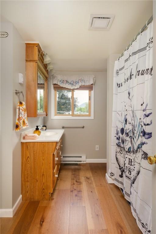 514 Maple St, Big Flats, NY 14814 - bathroom featuring wood finished floors, baseboard heating, and vanity