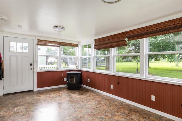 514 Maple St, Big Flats, NY 14814 - unfurnished sunroom featuring a wood stove, stone finish flooring, and healthy amount of natural light