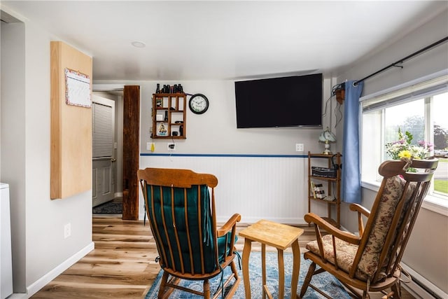 514 Maple St, Big Flats, NY 14814 - living area featuring baseboard heating, wood finished floors, and a wainscoted wall