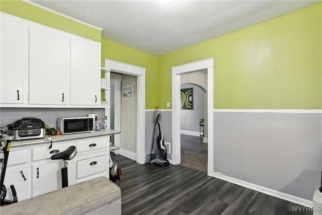 2224 Walnut Ave, Niagara Falls, NY 14301 - kitchen with arched walkways, white cabinetry, dark wood-style flooring, light countertops, and wainscoting