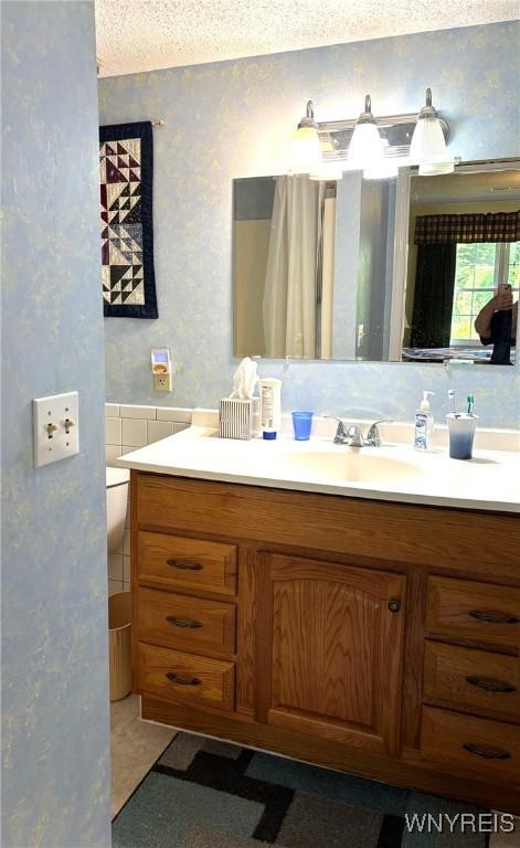 3 Homer Ln Unit B, Amherst, NY 14221 - bathroom featuring vanity, wallpapered walls, and a textured ceiling