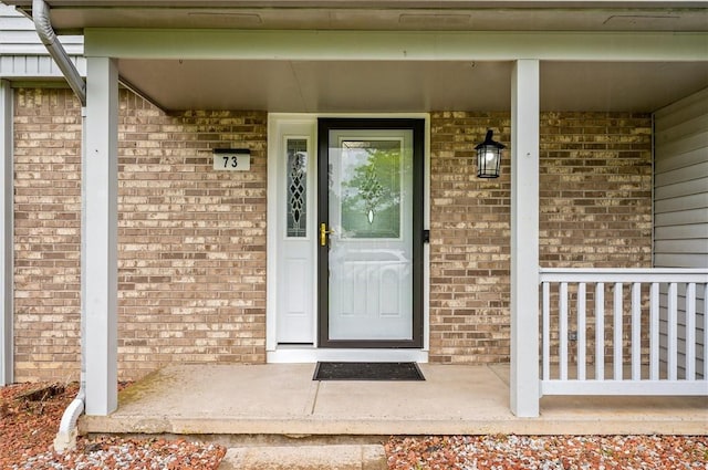 73 Hazel Bark Run, Gates, NY 14606 - doorway to property featuring covered porch and brick siding