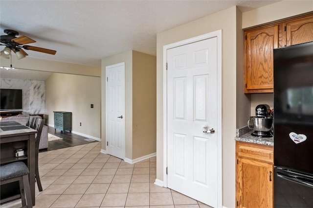 73 Hazel Bark Run, Gates, NY 14606 - kitchen with freestanding refrigerator, a ceiling fan, open floor plan, light tile patterned floors, and brown cabinets