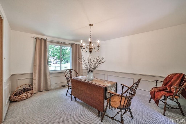 79 Pin Oak Cir, Grand Island, NY 14072 - carpeted dining space featuring a chandelier, a wainscoted wall, and a decorative wall