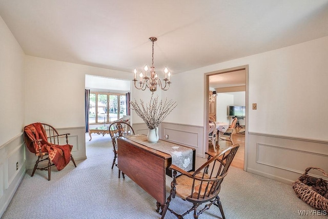 79 Pin Oak Cir, Grand Island, NY 14072 - dining space featuring a chandelier, wainscoting, a decorative wall, and light carpet