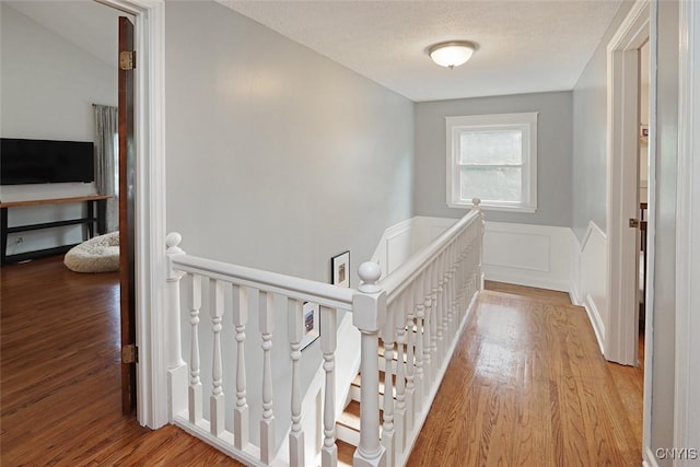 105 Maple Dr, Dewitt, NY 13066 - hallway with an upstairs landing, wood finished floors, and wainscoting