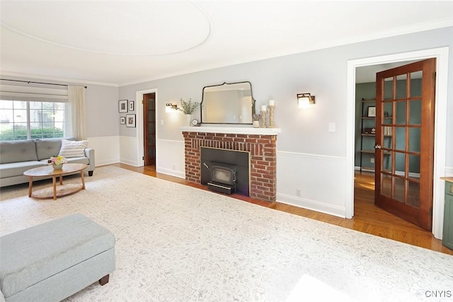 105 Maple Dr, Dewitt, NY 13066 - living room featuring wood finished floors, a wood stove, crown molding, and wainscoting