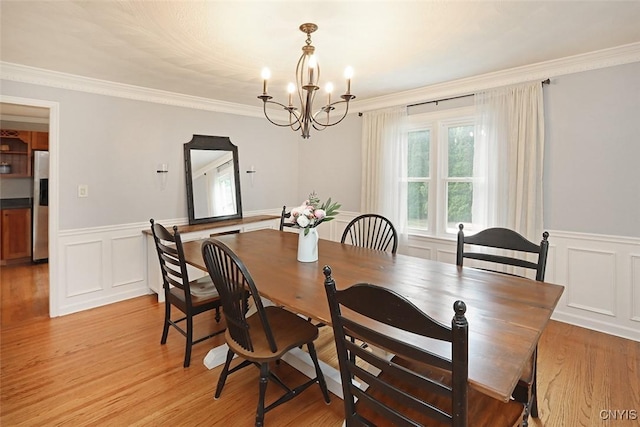 105 Maple Dr, Dewitt, NY 13066 - dining room featuring a chandelier, wainscoting, ornamental molding, light wood-style flooring, and arched walkways