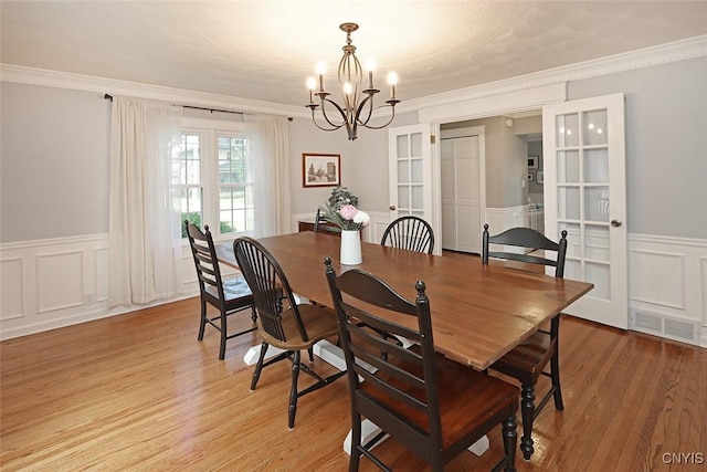 105 Maple Dr, Dewitt, NY 13066 - dining room with a chandelier, wainscoting, ornamental molding, light wood-style flooring, and a decorative wall