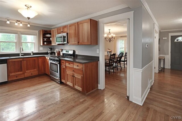 105 Maple Dr, Dewitt, NY 13066 - kitchen featuring stainless steel appliances, crown molding, dark countertops, healthy amount of natural light, and light wood-type flooring