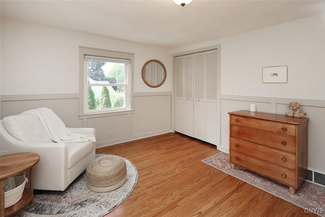 105 Maple Dr, Dewitt, NY 13066 - living area with light wood-style flooring, a decorative wall, and wainscoting