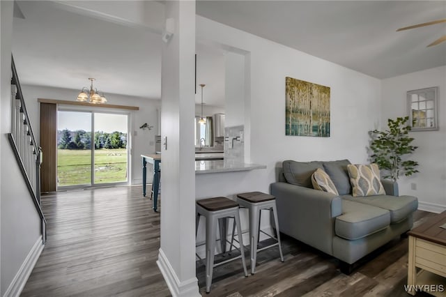 3866 Stone Ridge Rd, Wheatfield, NY 14120 - living room featuring dark wood finished floors, a chandelier, a ceiling fan, and stairway