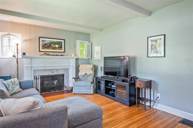 1463 Lehigh Station Rd, Henrietta, NY 14467 - living room featuring beam ceiling, wood finished floors, and a brick fireplace