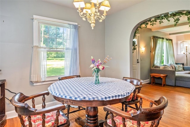 1463 Lehigh Station Rd, Henrietta, NY 14467 - dining space featuring arched walkways, a chandelier, and wood finished floors