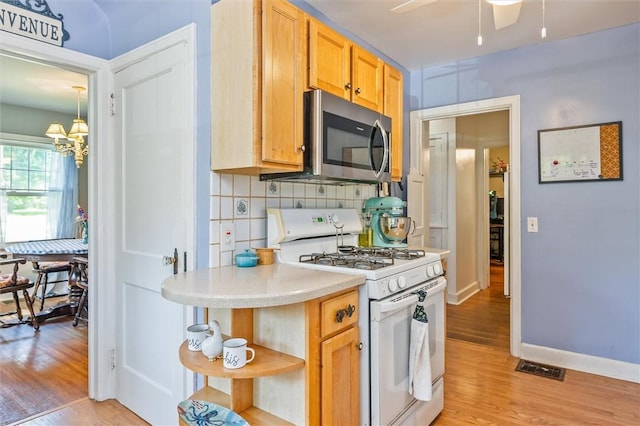 1463 Lehigh Station Rd, Henrietta, NY 14467 - kitchen featuring white gas range oven, stainless steel microwave, light wood-style flooring, light countertops, and open shelves