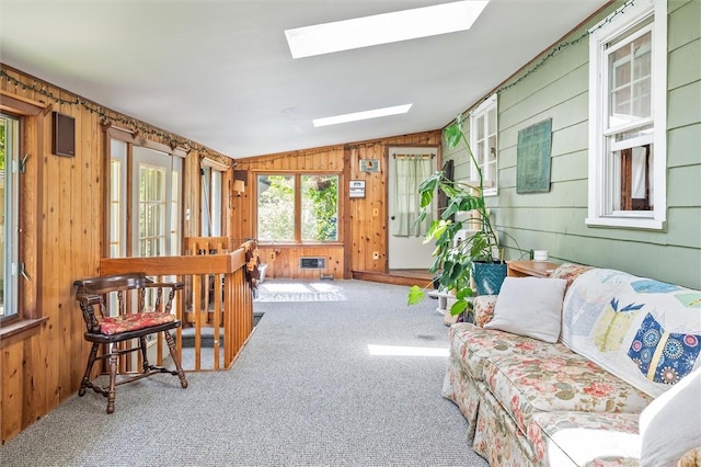 1463 Lehigh Station Rd, Henrietta, NY 14467 - living room featuring carpet flooring, vaulted ceiling, wooden walls, and a skylight
