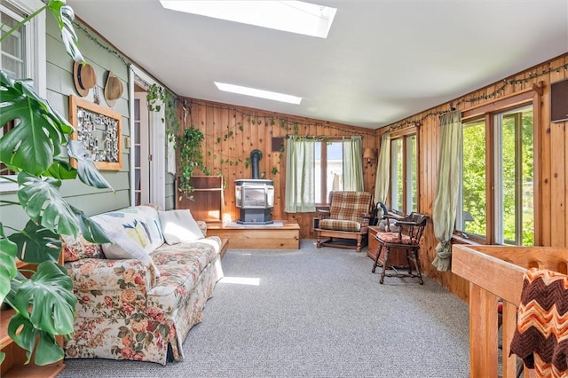 1463 Lehigh Station Rd, Henrietta, NY 14467 - carpeted living room featuring a wood stove, lofted ceiling, a skylight, and wood walls