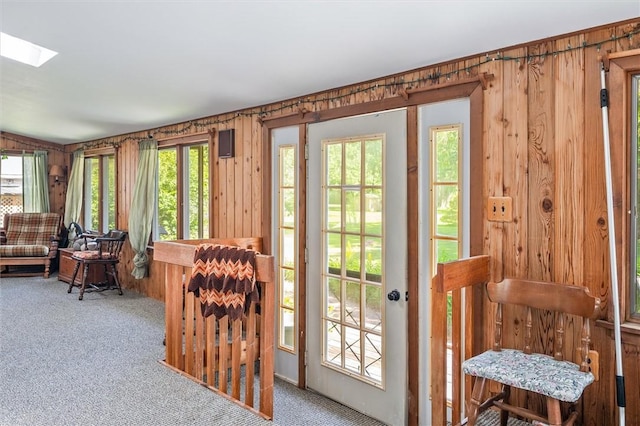 1463 Lehigh Station Rd, Henrietta, NY 14467 - doorway to outside featuring carpet flooring, a skylight, and wood walls