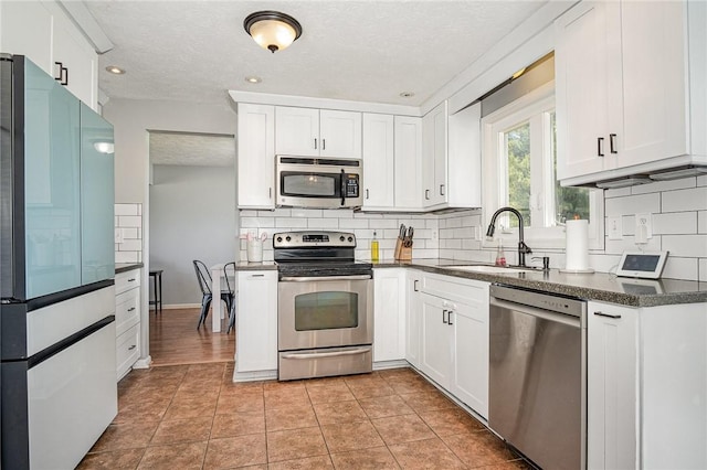 3487 Scenic Way, Walworth, NY 14502 - kitchen with appliances with stainless steel finishes, decorative backsplash, white cabinets, a textured ceiling, and recessed lighting