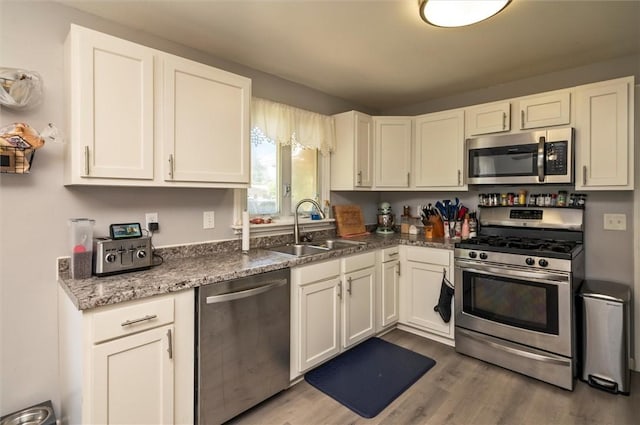 363 Kartes Dr, Greece, NY 14616 - kitchen featuring appliances with stainless steel finishes, wood finished floors, and white cabinetry