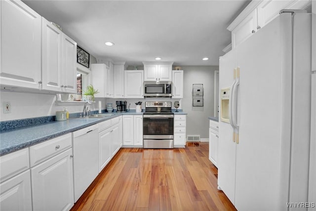 4964 Meadowbrook Rd, Clarence, NY 14221 - kitchen with appliances with stainless steel finishes, light wood finished floors, white cabinetry, recessed lighting, and dark countertops