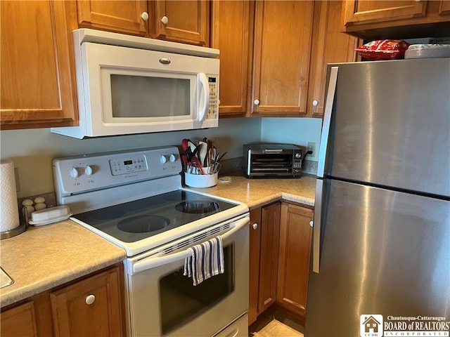 34 Oneida Dr, Chautauqua, NY 14728 - kitchen featuring white appliances, brown cabinets, and light countertops